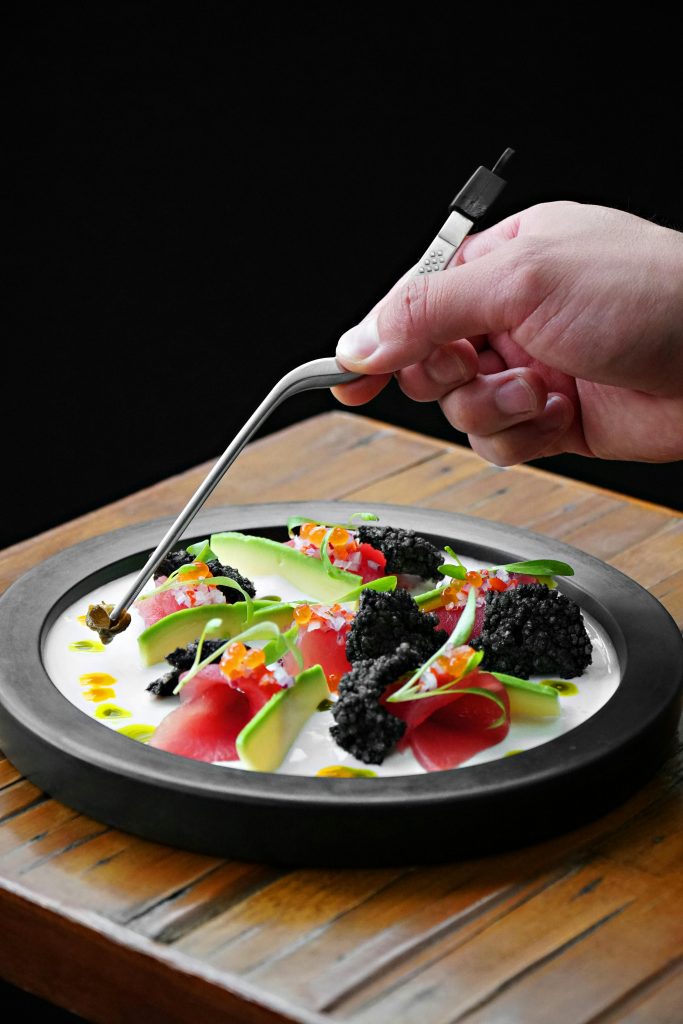 A gourmet dish featuring vibrant Peruvian ingredients, artistically plated with a dark background for contrast.